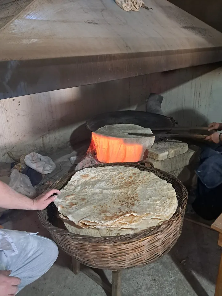 Makinede açılan köy yufkası odun ateşinde sac üzerinde pişerken
